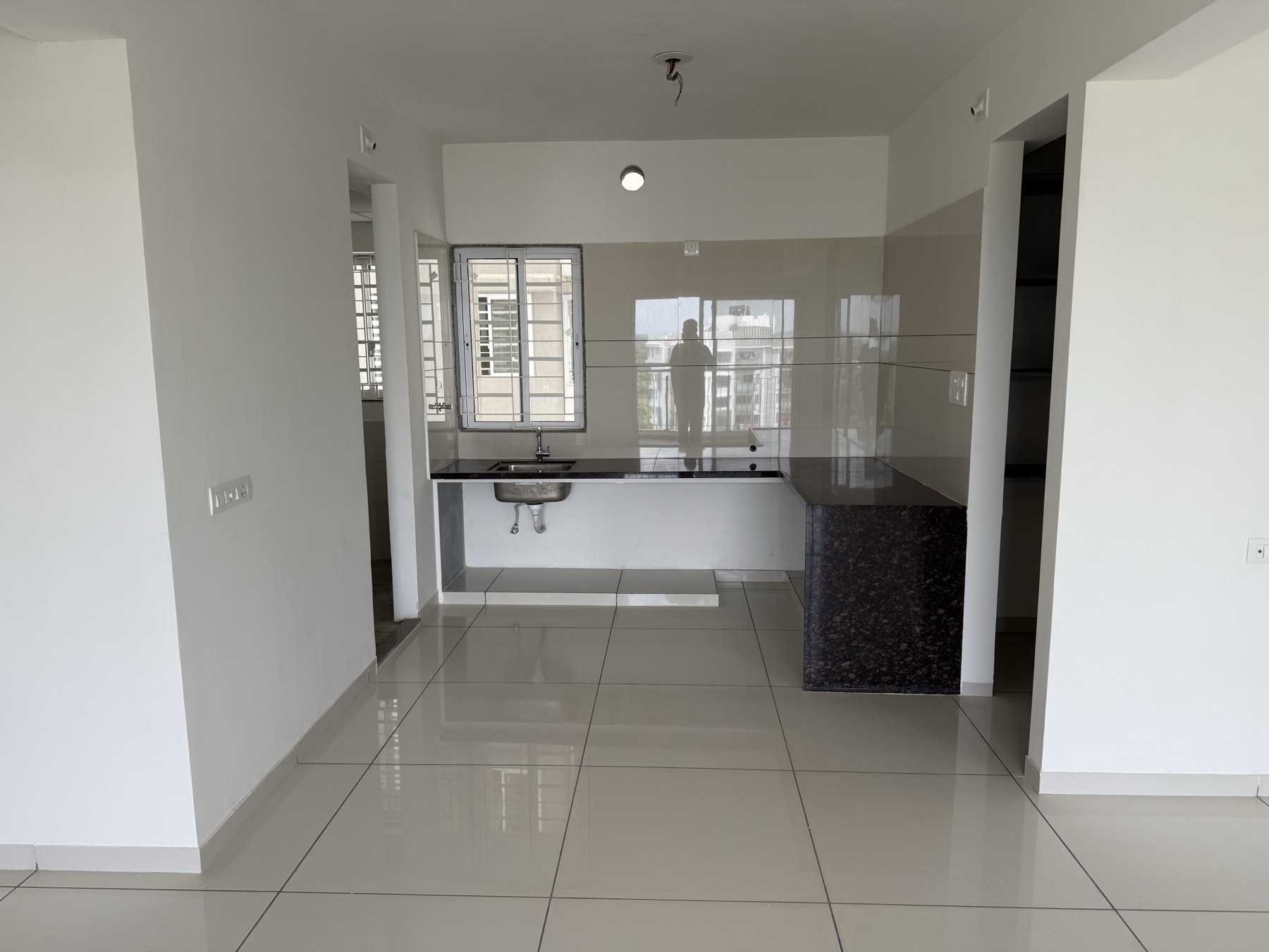 Kitchen with granite platform, store room entrance on the right and wash area on the left
